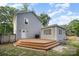 Backyard view of a gray home featuring a spacious wooden deck and manicured lawn at 5421 Princess St, Charlotte, NC 28269