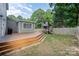 Spacious backyard featuring a wooden deck, fenced-in yard, and a charming playhouse at 5421 Princess St, Charlotte, NC 28269