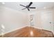 Bedroom featuring hardwood floors, a ceiling fan, and a doorway leading to a bathroom at 5421 Princess St, Charlotte, NC 28269