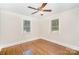 This bedroom features a ceiling fan, hardwood floors, and two windows that allow natural light to flood the room at 5421 Princess St, Charlotte, NC 28269