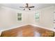 Inviting bedroom with hardwood floors, ceiling fan, and natural light streaming through the windows at 5421 Princess St, Charlotte, NC 28269