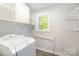 Functional laundry room with a washing machine, overhead cabinets, and wire shelving for ample storage at 5421 Princess St, Charlotte, NC 28269
