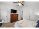 Cozy bedroom featuring a ceiling fan, large dresser with TV and a bright white wall at 5730 Closeburn Rd # H, Charlotte, NC 28210