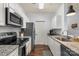 Modern kitchen featuring stainless appliances, granite countertops, and sleek white cabinets at 5730 Closeburn Rd # H, Charlotte, NC 28210