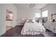 Serene bedroom with wood floors, natural light, and a glimpse into an ensuite bathroom at 5918 Barrowlands Ct, Charlotte, NC 28210