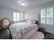 Inviting bedroom featuring hardwood floors, a plush rug, and comfortable bed adorned with decorative pillows and stylish bedding at 5918 Barrowlands Ct, Charlotte, NC 28210