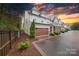 Beautiful townhome with a two car garage, manicured landscaping, and sunset sky at 5918 Barrowlands Ct, Charlotte, NC 28210