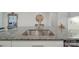 Close-up of a kitchen island with a stainless steel sink, granite countertop, and decorative mirror at 5918 Barrowlands Ct, Charlotte, NC 28210