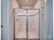 A tiled shower features a glass door and built-in seating at 5918 Barrowlands Ct, Charlotte, NC 28210