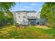 Large back exterior view of a light blue home with a deck, patio, and a fire pit surrounded by green lawn at 6424 Chadwell Ct, Fort Mill, SC 29707
