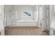 Bathroom featuring a walk-in shower, large tub, window, and neutral tile at 6424 Chadwell Ct, Fort Mill, SC 29707