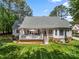 Landscaped backyard with a spacious deck, manicured lawn, and mature trees creating a serene retreat at 6990 Ridgeway Rd, Stanley, NC 28164