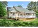 A well-maintained backyard featuring a spacious deck, lush lawn, and mature trees at 6990 Ridgeway Rd, Stanley, NC 28164