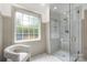 Bright bathroom featuring a glass enclosed shower with bench, a neutral color palette and a window at 6990 Ridgeway Rd, Stanley, NC 28164