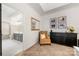 Spacious bedroom with a sitting area, featuring an accent chair, dresser, and an ensuite bathroom at 6990 Ridgeway Rd, Stanley, NC 28164