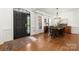 Formal dining room with hardwood floors, elegant chandelier, and black entry door at 6990 Ridgeway Rd, Stanley, NC 28164