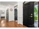 Hallway with hardwood floors, black doors, and white trim, offering a glimpse of the exterior at 6990 Ridgeway Rd, Stanley, NC 28164