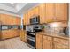 Well-equipped kitchen featuring wooden cabinetry, modern appliances, and tiled backsplash at 6990 Ridgeway Rd, Stanley, NC 28164