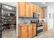 Modern kitchen with stainless steel appliances, stone backsplash, wood cabinets, and a nearby pantry at 6990 Ridgeway Rd, Stanley, NC 28164