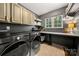 Laundry room equipped with modern washer and dryer, storage cabinets, and a functional folding table at 6990 Ridgeway Rd, Stanley, NC 28164