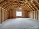 Unfinished attic space featuring exposed framing, natural lighting and wood flooring at 709 Cavesson Way, Monroe, NC 28110