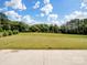 A large, empty backyard with trees in the distance on a sunny day at 709 Cavesson Way, Monroe, NC 28110