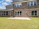 Backyard featuring brick home exterior, with green grass and concrete patio at 709 Cavesson Way, Monroe, NC 28110