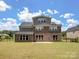 Back exterior of home featuring brick, multiple windows, concrete patio and lush backyard at 709 Cavesson Way, Monroe, NC 28110