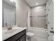 Bathroom featuring a dark wood vanity, neutral tiling, and shower and bathtub combination at 709 Cavesson Way, Monroe, NC 28110