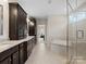 Bathroom with a double vanity, granite countertops, cabinets, and a glass-enclosed shower and separate tub at 709 Cavesson Way, Monroe, NC 28110