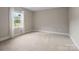 An empty bedroom space featuring carpet flooring, neutral paint, and bright, natural light at 709 Cavesson Way, Monroe, NC 28110