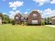 Charming two-story brick home with a well-manicured lawn and beautiful landscaping at 709 Cavesson Way, Monroe, NC 28110