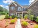 Inviting front view of a two-story brick home with a covered entrance and mature shrubs at 709 Cavesson Way, Monroe, NC 28110