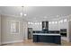 Spacious kitchen featuring white cabinets, a dark blue island, and stainless steel appliances at 709 Cavesson Way, Monroe, NC 28110
