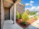 Covered porch showing brick facade, square support columns, and small trees at 709 Cavesson Way, Monroe, NC 28110