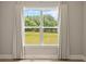 Bright window with decorative curtains offering a view of the lush outdoor landscape at 709 Cavesson Way, Monroe, NC 28110