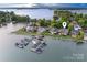 Aerial view showcases waterfront property with private boat docks, green landscaping, and serene lake setting at 7220 Swansea Ln, Cornelius, NC 28031