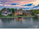 Spacious backyard view of waterfront homes, with well-kept lawns and private access to the lake at 7220 Swansea Ln, Cornelius, NC 28031