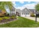 Charming two-story gray home featuring a two-car garage and beautifully landscaped front yard at 7220 Swansea Ln, Cornelius, NC 28031
