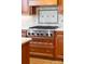 Close-up of Thermador stovetop with cherry wood cabinets and light countertops at 7220 Swansea Ln, Cornelius, NC 28031