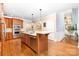 Open kitchen with island and hardwood floors, showcasing stainless steel appliances at 7220 Swansea Ln, Cornelius, NC 28031