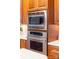 Stainless steel microwave and oven built into cherry wood cabinets at 7220 Swansea Ln, Cornelius, NC 28031