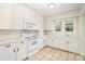 Bright kitchen with white cabinets, appliances, and countertops, features a window over the sink at 813 S Ridge Ave, Kannapolis, NC 28083
