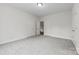 A white walled room with gray carpet and 3 doors leading to another area of the home at 8505 Loxton Cir, Charlotte, NC 28214