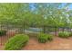 The community pool can be seen behind bushes and a fence at 8505 Loxton Cir, Charlotte, NC 28214