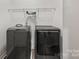 Laundry room with black washer and dryer and wire shelving for storage solutions at 8505 Loxton Cir, Charlotte, NC 28214