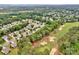 Aerial view showcasing a neighborhood bordering a golf course with lush landscaping at 8938 Kestral Ridge Dr, Charlotte, NC 28269