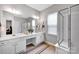 Bright bathroom with double vanity, framed mirrors, tiled floor and glass shower stall at 8938 Kestral Ridge Dr, Charlotte, NC 28269