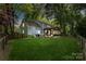 Expansive backyard featuring a covered patio and lush green lawn illuminated at dusk at 9238 Deer Spring Ln, Charlotte, NC 28210