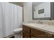 Functional bathroom with a white shower curtain, wood vanity, and sink, offering a clean and practical space at 9238 Deer Spring Ln, Charlotte, NC 28210